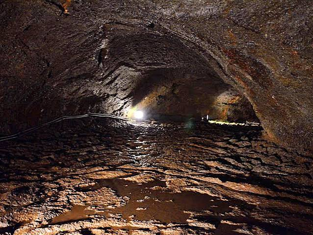Interior of a lava tunnel with water flowing along the floor