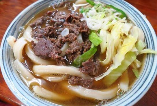 A bowl of Yoshida udon topped with beef and cabbage