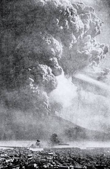 Archival photo of a massive ash column rising over the city during the 1914 Taisho eruption