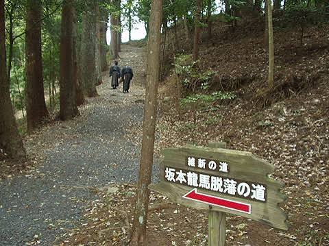 維新の道と書かれた脱藩の道の標識と歩く人々