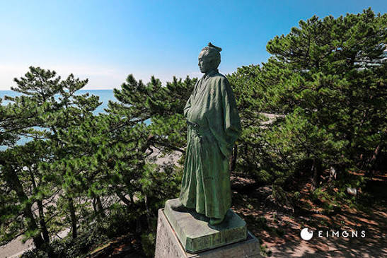 The statue of Sakamoto Ryoma at Katsurahama, framed by pines and the Pacific