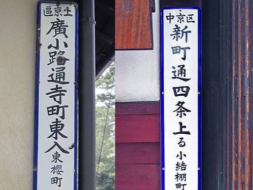 An old enamel address plate showing 'agaru' and 'nishi-iru'.