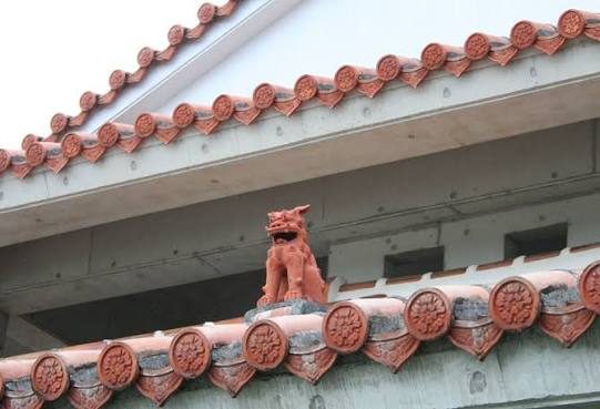 A shisa on a red-tiled roof