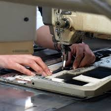 A craftsperson's hands sewing a Toyooka bag on a machine